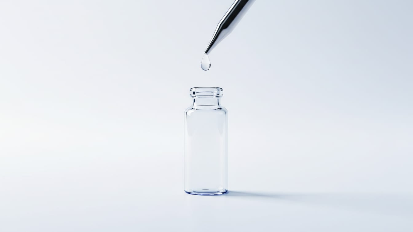 Illustration: A clear glass vial with a pipette dispensing a single drop of liquid on a white surface.