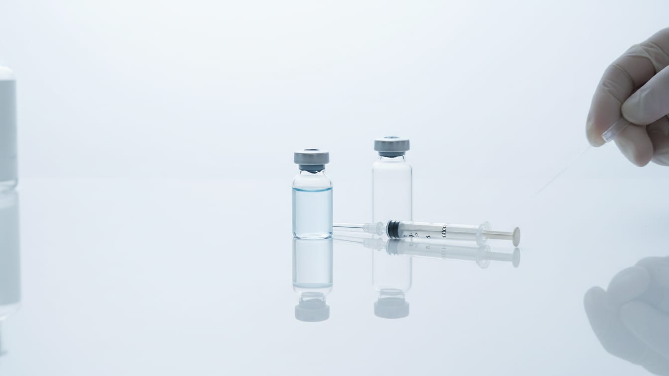 Illustration: Two clear glass vials, one with pale blue liquid, one empty, and an insulin syringe.