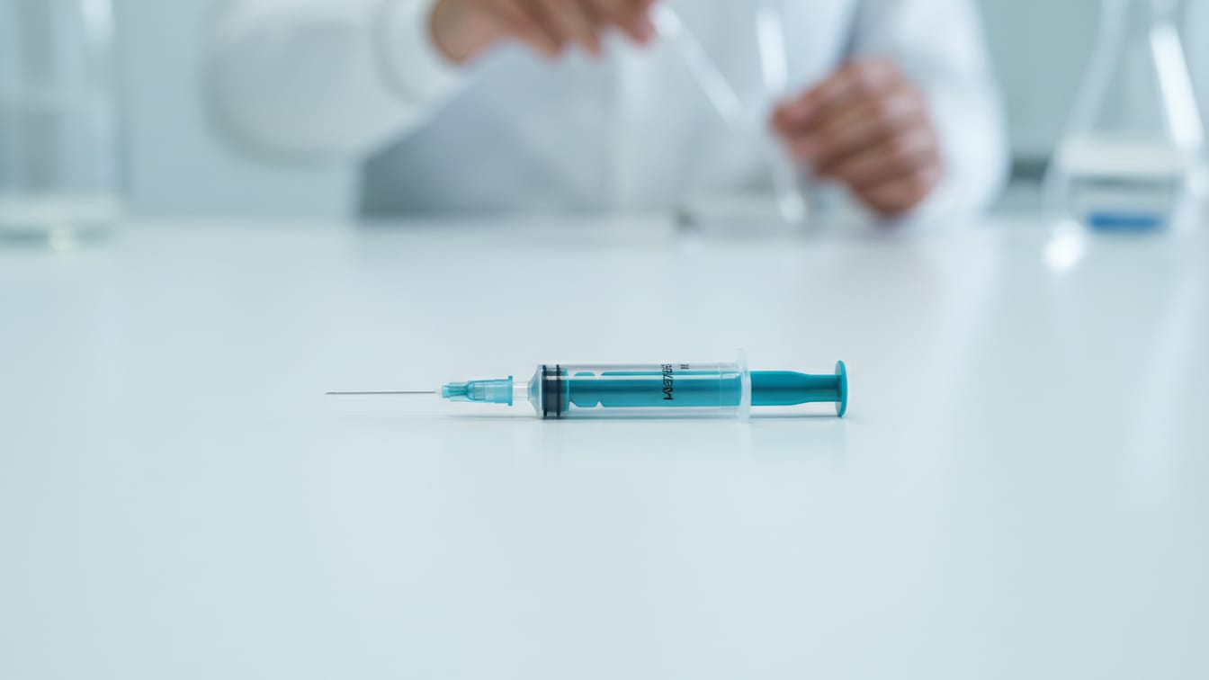 Illustration: An empty insulin syringe resting on a white surface, bathed in soft, even light.